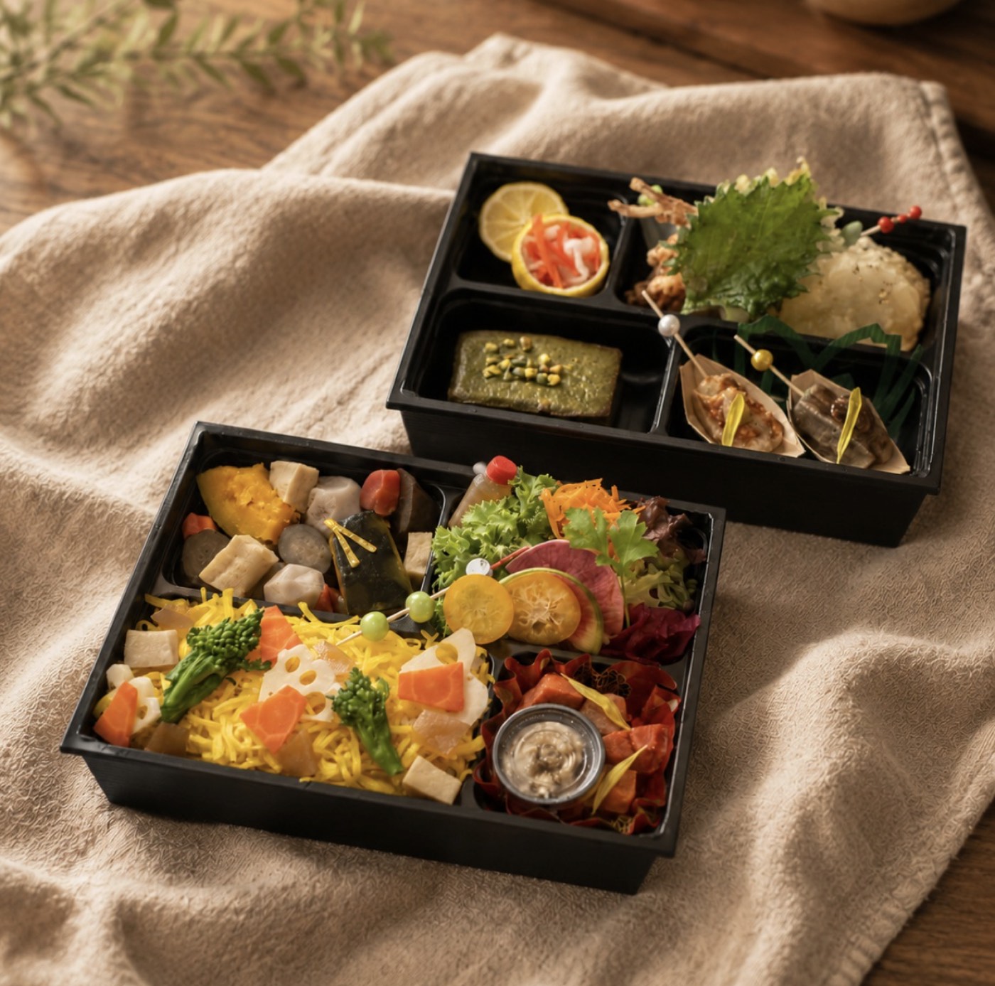 Two-tiered vegan bento with seasonal vegetables and small dishes